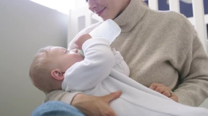 4k视频片段，一个可爱的男婴在家中被母亲喂奶瓶