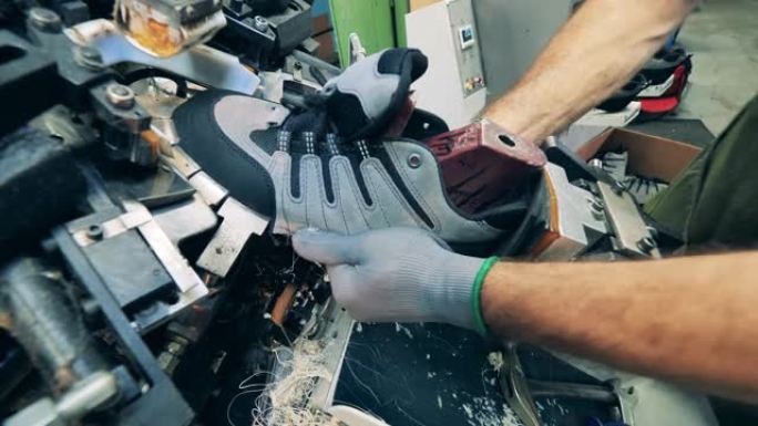 鞋匠使用机器将鞋子定型