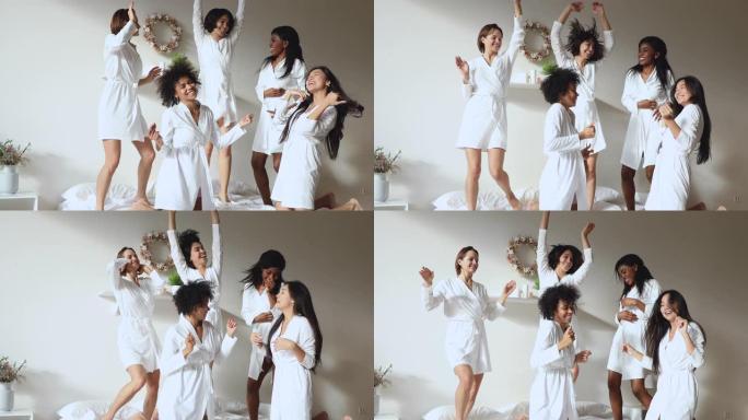 穿着白色浴袍的多样化美女在床上跳舞。