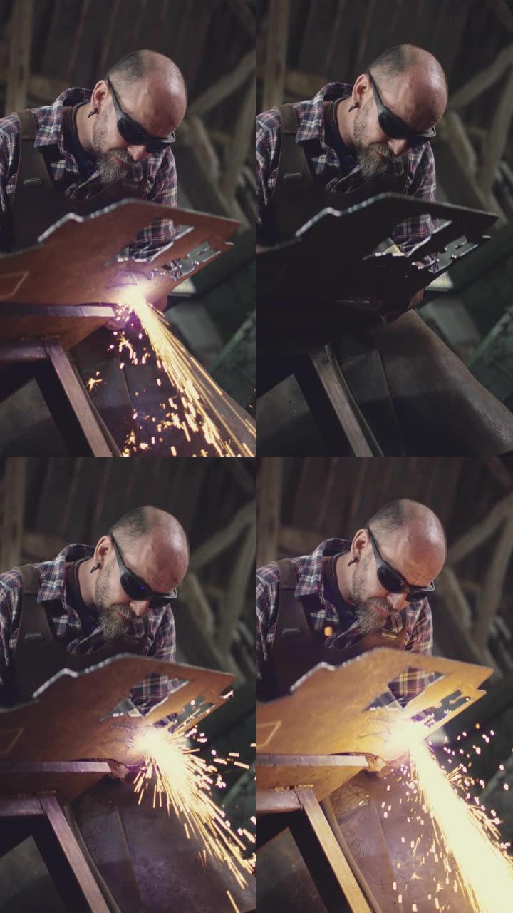 男性铁匠使用等离子切割机从锻造的钣金切割形状的垂直视频