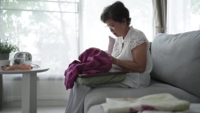 退休的成熟女人在周末爱好面料和刺绣