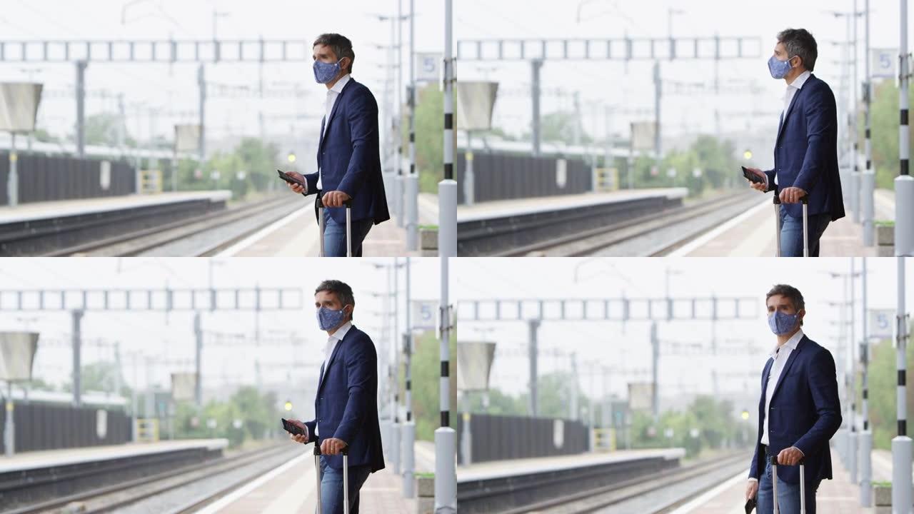 健康大流行期间戴着PPE口罩的铁路平台上的商人