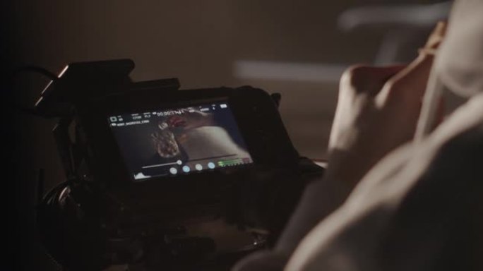 一位专业的视频操作员在拍摄电影时在相机的屏幕上观看素材