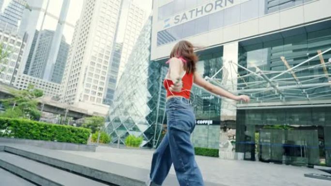 无忧无虑的女人在城市里听音乐和户外跳舞。