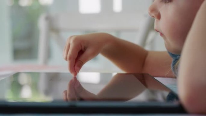 快乐孩子使用平板电脑小女孩在触摸屏设备上画画享受童年创造力在家玩移动设备游戏4k