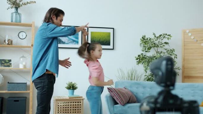 亚洲家庭爸爸和女儿挥舞着手，然后跳舞为vlog录制高五视频