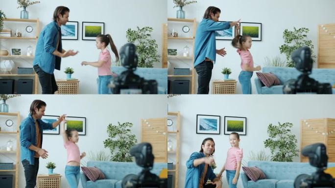 亚洲家庭爸爸和女儿挥舞着手，然后跳舞为vlog录制高五视频
