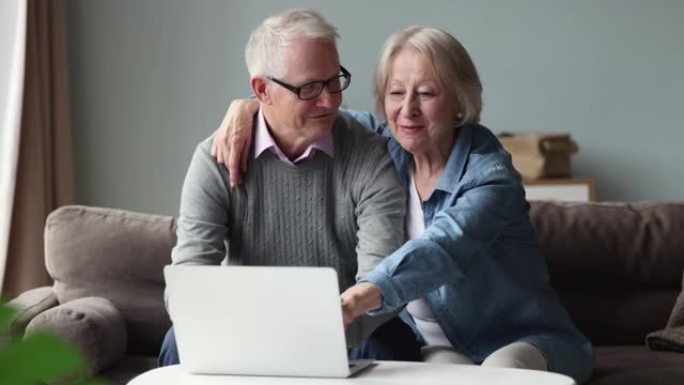 已婚退休夫妇在家中使用笔记本电脑