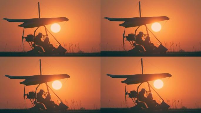 在美丽的日落背景下通过悬挂式滑翔机进行飞行测试的准备
