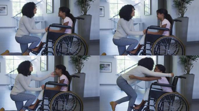 非裔美国母亲抱着坐在医院轮椅上的女儿