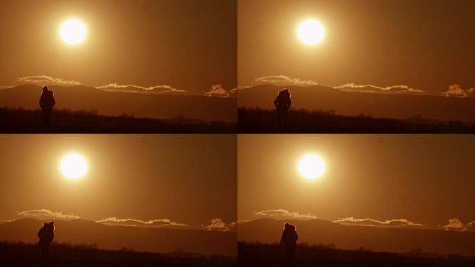 日落时在山上放松的剪影中的SLO MO WS女人