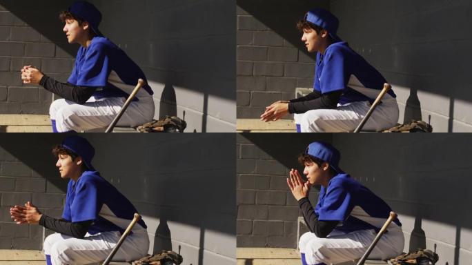 紧张的混血女棒球选手，与棒球bal一起坐在长凳上晒太阳等待
