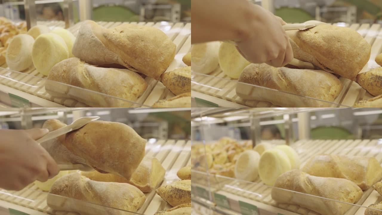 无法辨认的手用塑料钳捡起恰巴塔面包