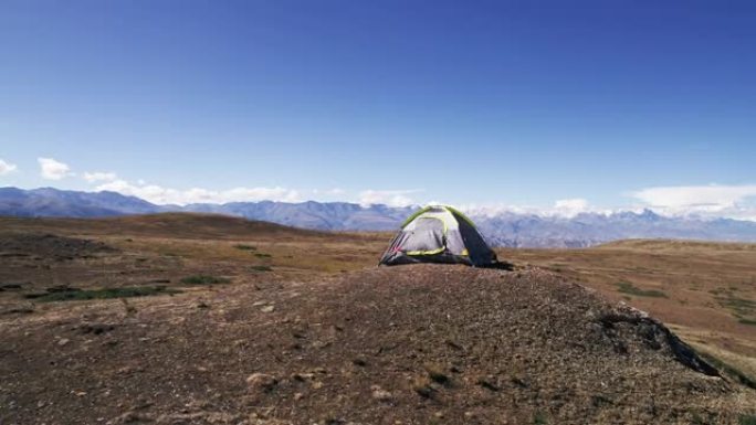 山顶上的旅行帐篷，背景是白雪皑皑的山峰