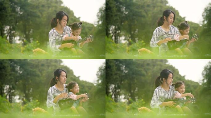 在公园野餐时，和她可爱的女儿玩夏威夷四弦琴