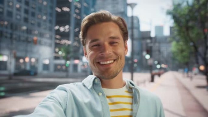 POV视频通话肖像，一个穿着便装的英俊年轻时尚男子站在城市街道外面与朋友或同事交谈。在城市环境中挥手