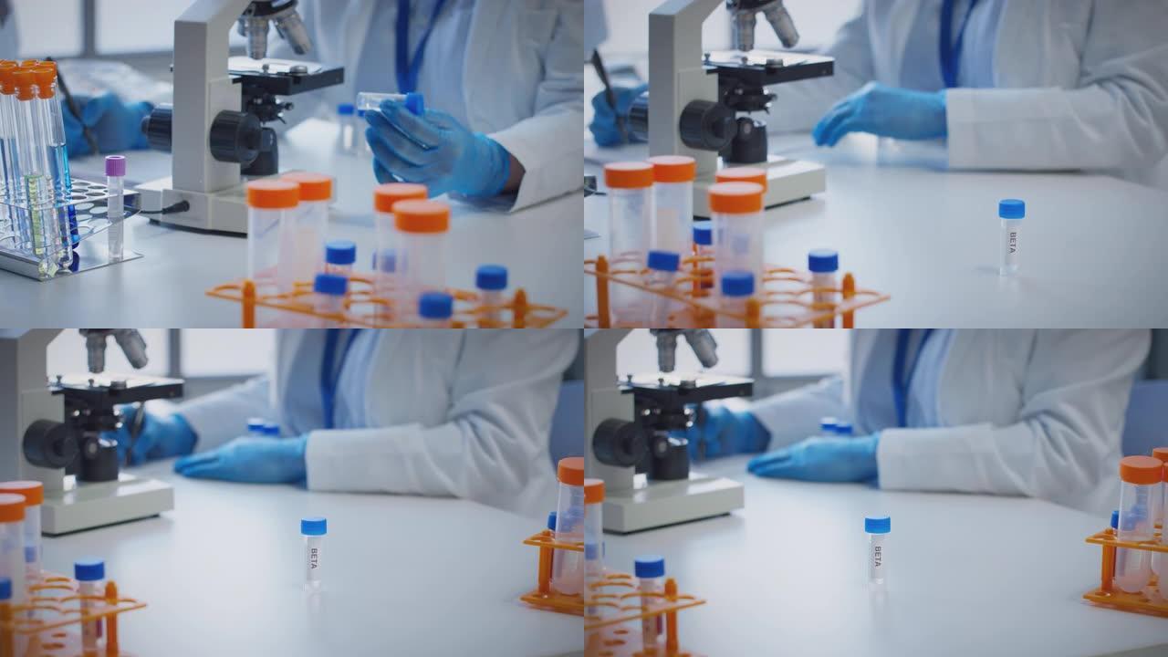 实验室工作人员使用显微镜进行研究，拿着标有β的试管