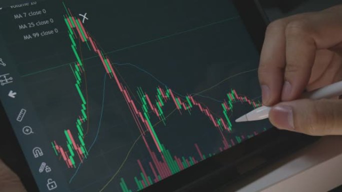 投资者分析检查数字平板电脑上的加密股票图表数据。