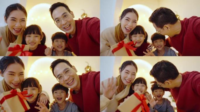 快乐的亚洲家庭和他们的孩子在圣诞节用手摇视频通话。