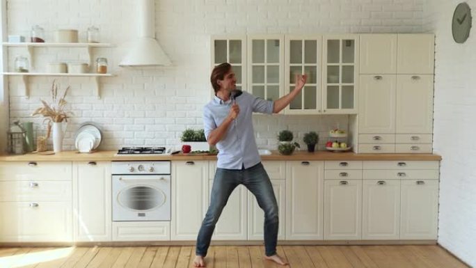 男人赤脚在厨房的地板上唱歌跳舞