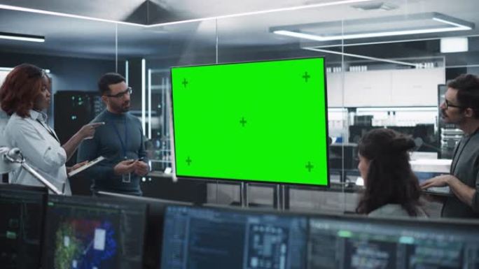 由不同软件开发人员组成的团队在带有绿屏模拟显示的会议室中开会。经理在办公室为项目经理做演示