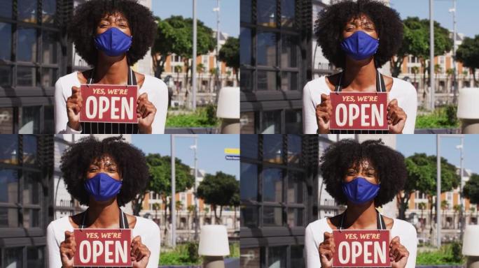 非裔美国女咖啡馆工作人员戴着面罩，展示着开放的标牌