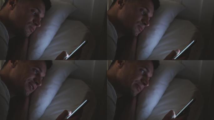 帅哥睡觉前滚动智能手机屏幕
