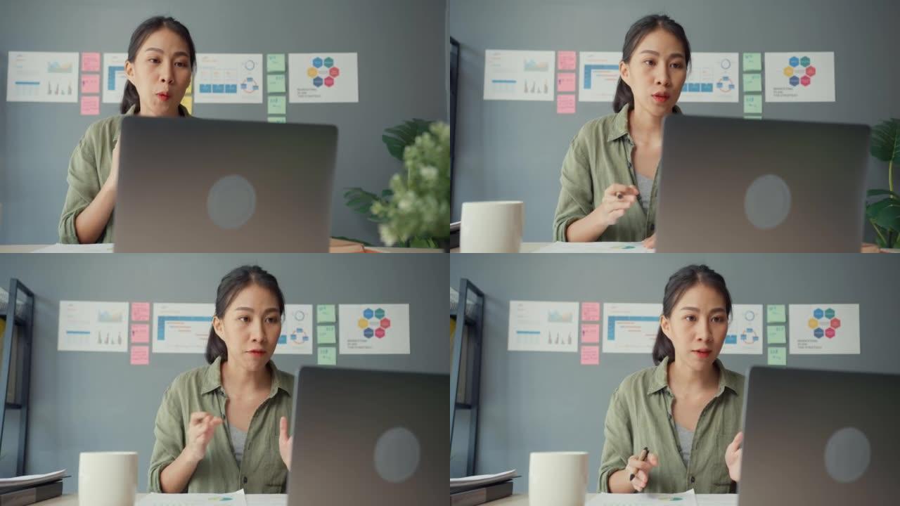 亚洲女商人在客厅在家工作时，使用笔记本电脑与同事讨论视频通话计划。远程工作场所，社交距离，检疫冠状病