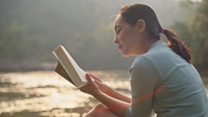 年轻女子在湖边看书放松