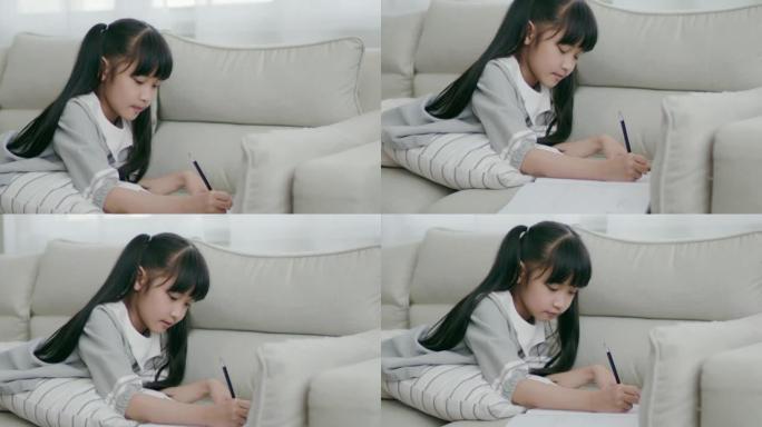 长发刘海可爱的亚洲女孩正在画自己的全家福，意图躺在肚子上。