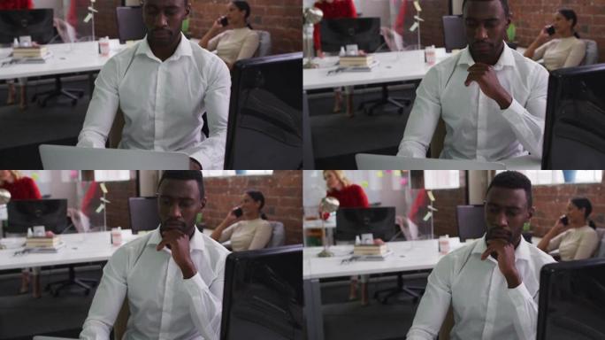 使用笔记本电脑坐在办公桌前的非裔美国商人的肖像