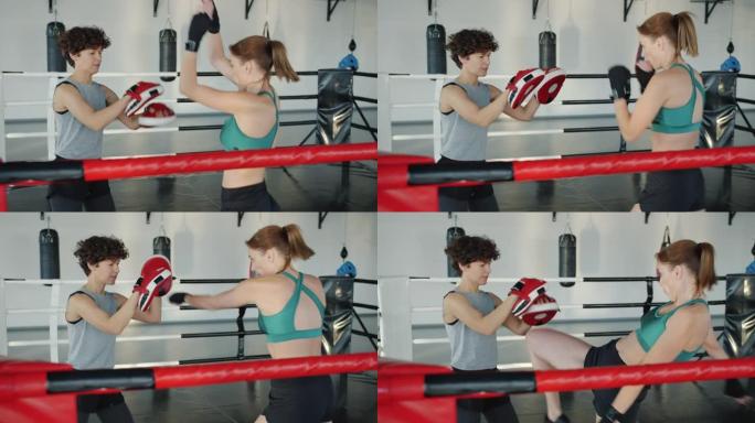 女跆拳道练习教练拳打脚踢集中在锻炼上