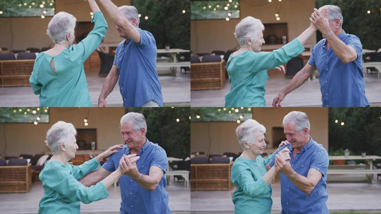 高年级白人夫妇在花园里跳舞和微笑