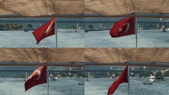 在夏季海洋和城市背景下，一艘游船在风中挥舞着土耳其国旗的美丽阳光明媚的景色。