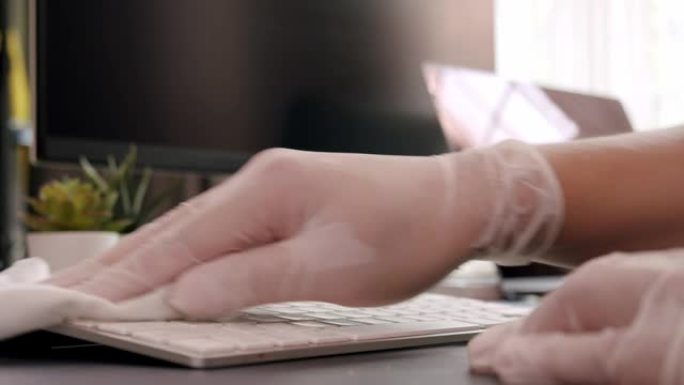 特写亚洲男子使用消毒湿巾清洁笔记本电脑清洁和抗菌冠状病毒或新型冠状病毒肺炎问题在家里的客厅，同时检疫