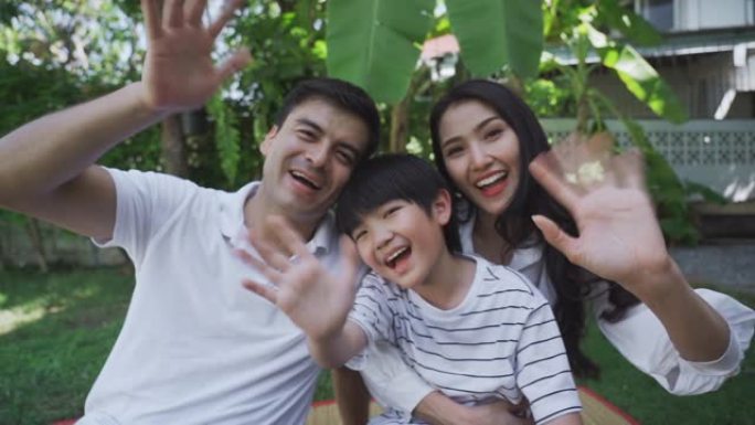 快乐的亚洲家庭挥手看着相机