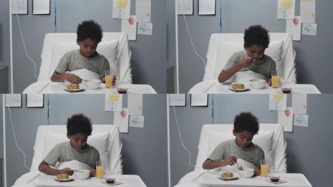 男孩在医院的病床上吃早餐