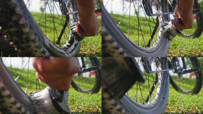 SLO MO无法识别的人使用刷子清洁山地自行车的车轮