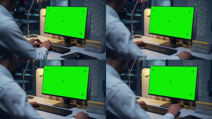 特写一位在台式计算机上工作的商人的色度键绿屏模拟显示。男性执行董事管理数字项目，使用键盘和鼠标键入数