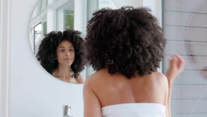 黑人女性，自然的头发和美丽，同时在浴室镜子里准备头发护理，生长洗发水和非洲护理在家。快乐的非洲模特在