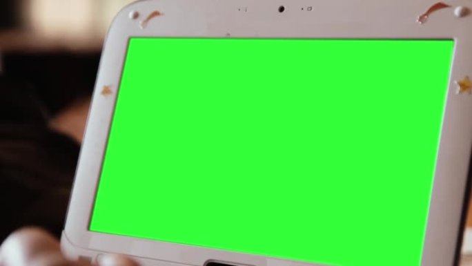 绿色屏幕的白色上网本电脑。放大。特写。