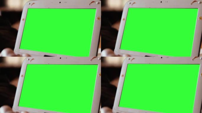 绿色屏幕的白色上网本电脑。放大。特写。