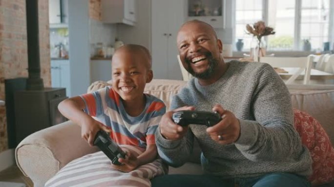 一个英俊的成熟男人和他的儿子在客厅玩电子游戏的4k视频片段