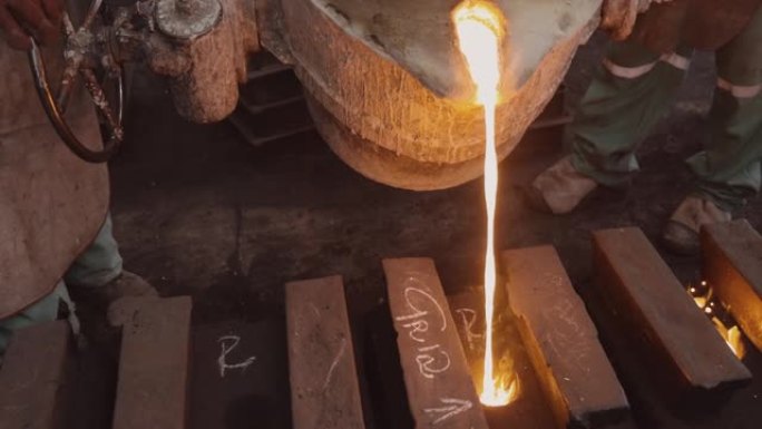工厂工人在铸钢铸造厂将熔融金属倒入铸件的特写镜头