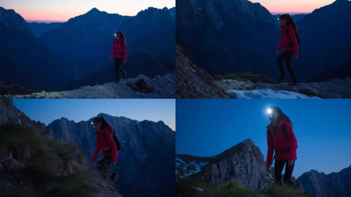 年轻的健身女子在黄昏时带着头灯在山上高高的远足