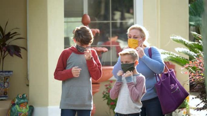 母亲和男孩离开家时戴上口罩