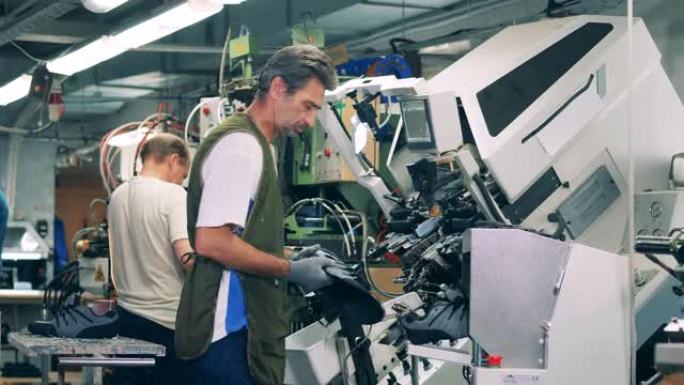 工业工人正在管理制造鞋子的工厂机器。制鞋厂的工人。