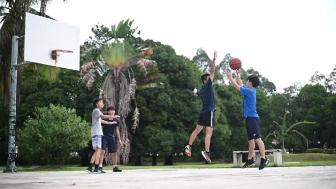 一组亚洲华裔少年少年放学后在篮球场打篮球练习
