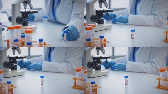 使用显微镜保存带有空白标签的血液样本进行研究的实验室工作人员的特写