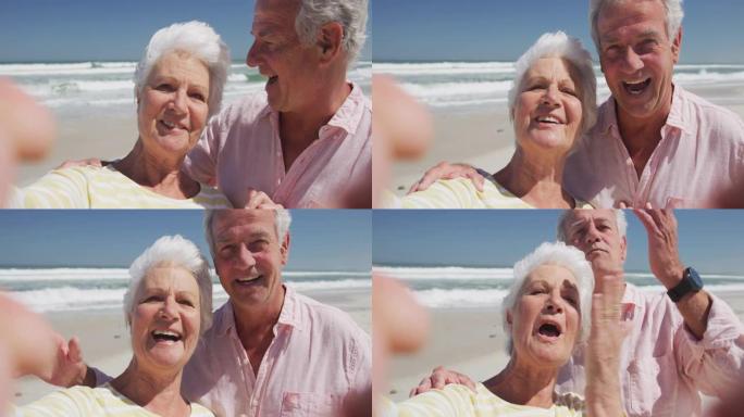 快乐的高级高加索夫妇在海滩上飞吻的肖像看着相机